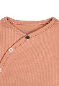 Rose ribbed fabric top with a V-neck design, featuring a dark button and a circular snap closure. Soft texture with subtle stitching detail.
