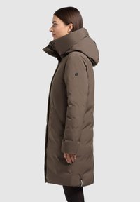 Cappotto imbottito marrone a lunghezza ginocchio con colletto alto e cappuccio ampio. Presenta tasche laterali e una finitura opaca con una silhouette elegante.