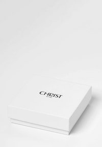 Weißer rechteckiger Geschenkekarton mit matter Oberfläche und in das Material geprägtem schwarzen Text "CHRIST seit 1863", der mittig auf dem Deckel platziert ist. Einfaches und elegantes Design.