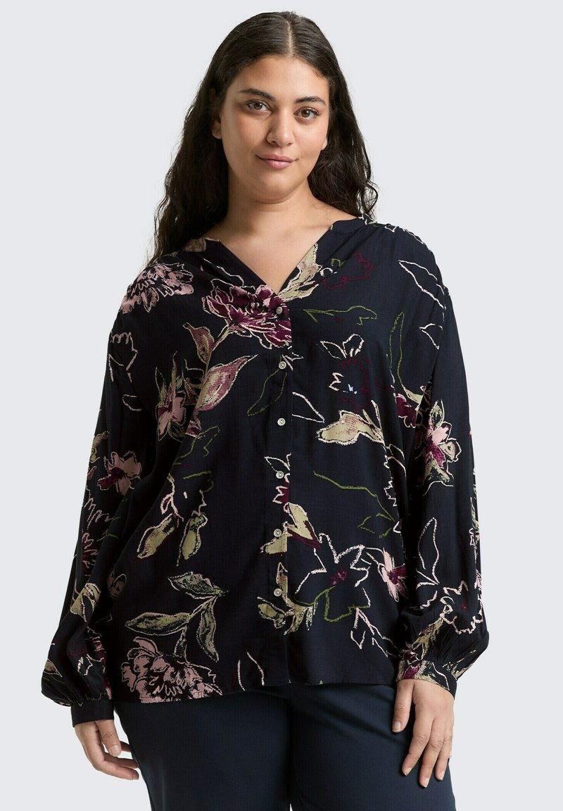 Dunkelbluse mit floralem Muster aus leichtem Stoff; mit langen Ärmeln, V-Ausschnitt und mehrfarbigen Blumenmustern auf navyfarbigem Hintergrund.