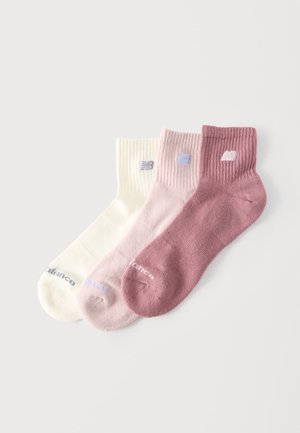 Drei Knöchelsocken in Creme, Hellrosa und Malve, jeweils mit einem gerippten Bündchen und einem kleinen weißen "NB"-Logo nahe der Oberseite.