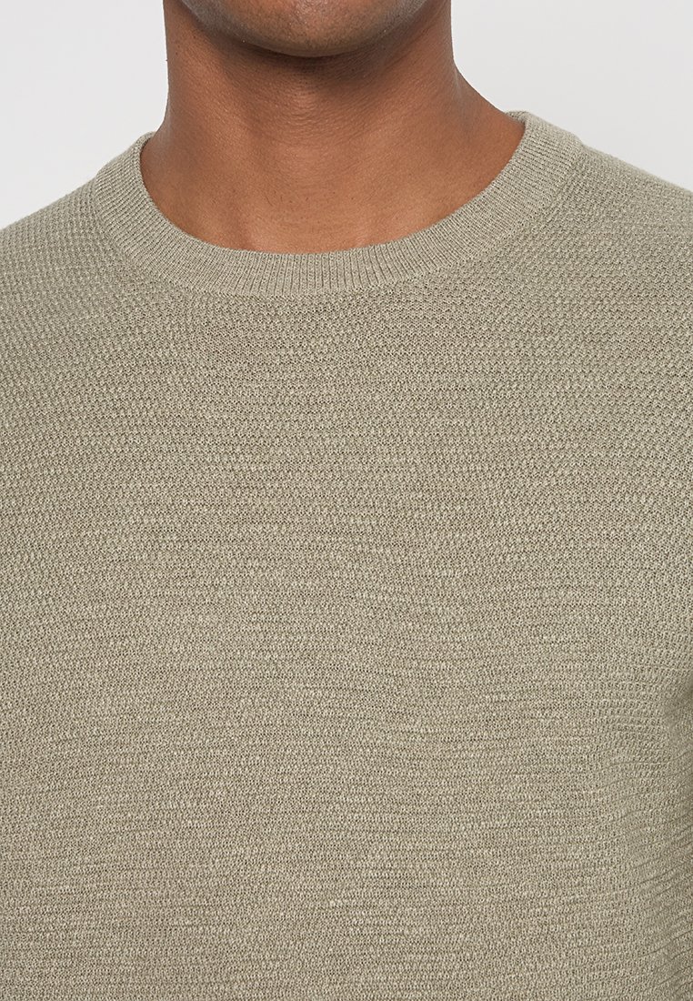 Lichtbeige gebreide trui met een ronde halslijn en gestructureerde stof. Kenmerkt zich door subtiele horizontale lijnen en een gladde afwerking.