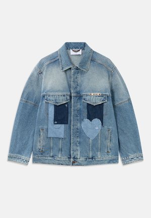 Veste en denim bleu clair avec des motifs en patchwork, comprenant des patches rectangulaires et en forme de cœur, des poches à rabat à l'avant et une fermeture à boutons.