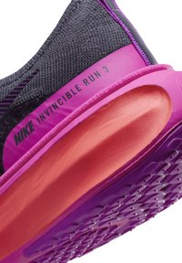 A Nike Invincible Run 3 sötétszürke texturált felsőrésszel, rózsaszín középtalppal és narancssárga talppal rendelkezik, amely körkörös bordázattal van ellátva.