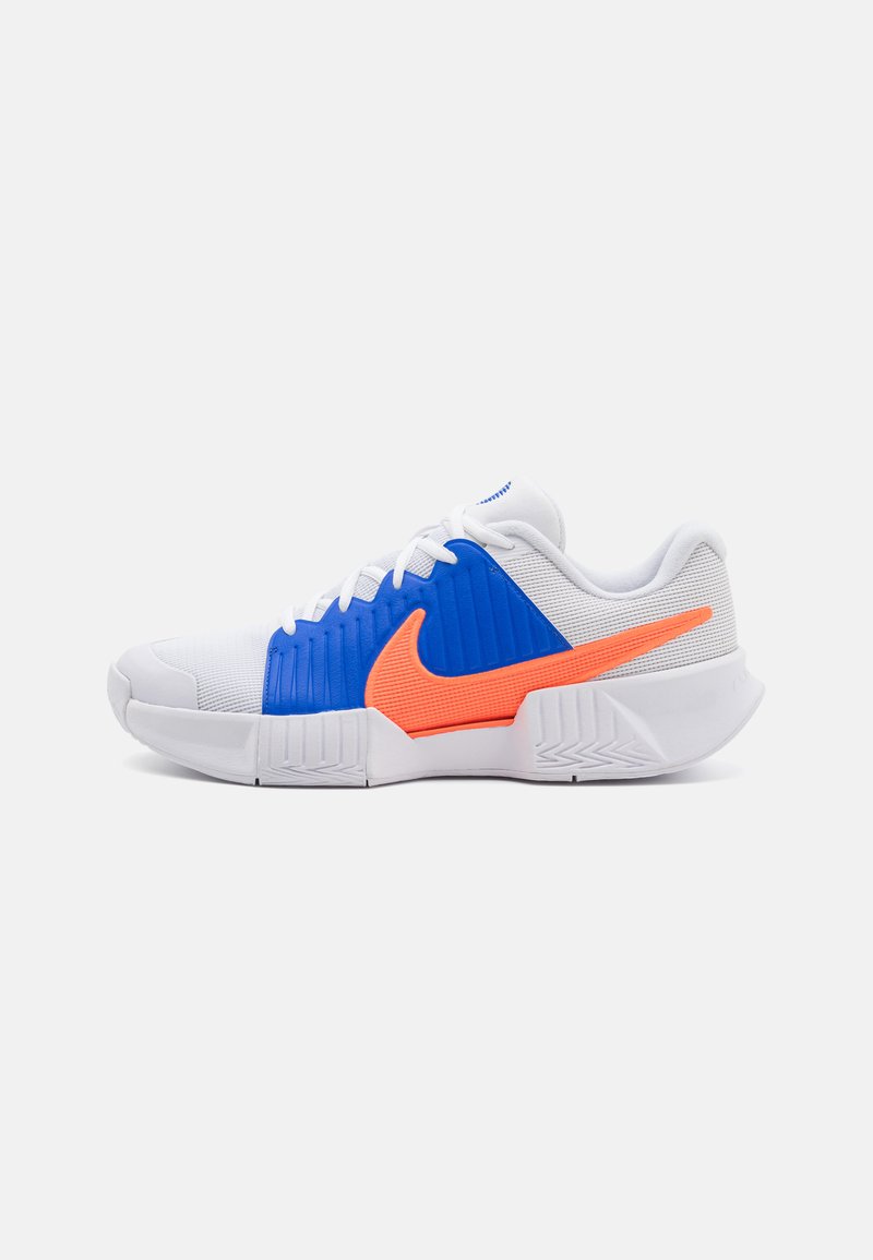 Weiße Sportschuhe mit blauen und orangefarbenen Akzenten, ausgestattet mit einem strukturierten Obermaterial, einer gepolsterten Sohle und einem auffälligen Logo.