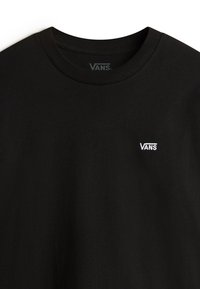 Schwarzes Baumwoll-T-Shirt mit Rundhalsausschnitt, ausgestattet mit einem kleinen weißen, gestickten "VANS"-Logo auf der linken Brustseite. Glatte Textur.