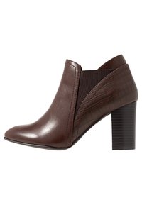 Botas de cuero marrón hasta el tobillo con punta afilada, que cuentan con un panel lateral texturizado, inserción elástica y un tacón negro apilado.