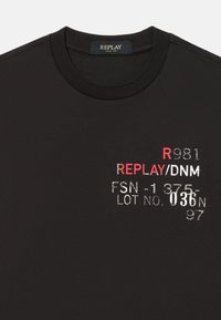 Svart bomulls t-skjorte med ribbet rund hals. Har trykt tekst i hvitt og rødt: "REPLAY/DNM," "FSN-1375," og "LOT NO. 036."