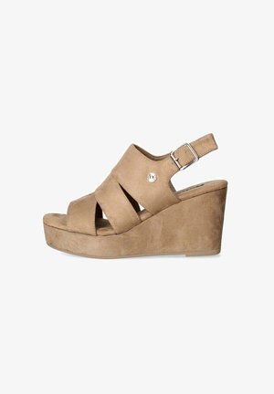 Sandali con zeppa in suede color cammello, con punta aperta, caratterizzati da cinturini incrociati e una chiusura con fibbia alla caviglia. L'altezza della zeppa è moderata.