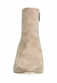 Stivale alla caviglia in suede beige con una texture liscia, design curvo e zip laterale per un facile accesso, dotato di una punta leggermente affusolata.