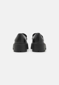 Zwarte leren schoenen met een ronde neus, lage hak en dikke rubberen zool met een gestructureerd loopvlak. Versterkte stiksels langs de naden.