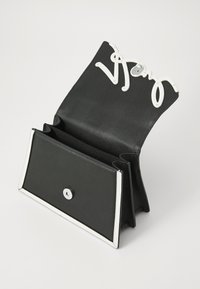 Borsa a tracolla in pelle nera con una superficie testurizzata. Presenta accenti bianchi e un design decorativo in metallo bianco per la chiusura.