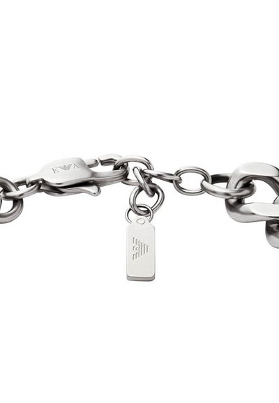 Bracelet en chaîne argentée avec des maillons entrelacés, doté d'un fermoir et d'une petite étiquette ornée d'un motif géométrique. Texture lisse et finition polie.