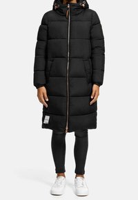 Svart puffjacka med huva, dragkedjestängning och två framfickor. Har quiltad textur och roséguld accentuerande detaljer.