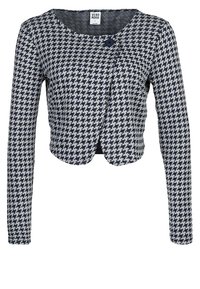 Marinblå och vit hundtandsrutigt kort cardigan med långa ärmar, rund halsringning och en enda knäppning. Mjuk stickad tyg.