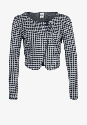 Cardigan court à carreaux pied-de-poule bleu marine et blanc, avec des manches longues, un col rond et une fermeture à un bouton. Tissu en tricot doux.