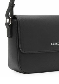 Bolso de hombro de cuero negro con cierre de solapa, herrajes plateados y logo grabado. Presenta un acabado texturizado y correa ajustable.