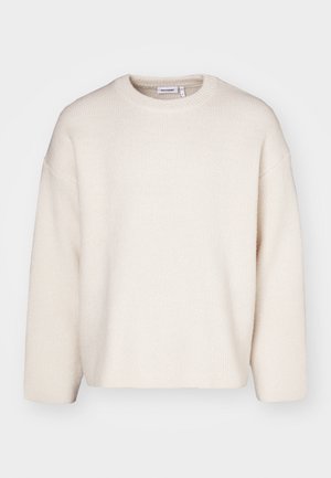 Kremowy sweter z teksturowanej dzianiny, z okrągłym dekoltem, obniżonymi ramionami i długimi rękawami. Prosty design bez zdobień.