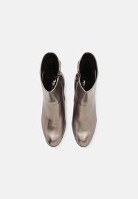 Botines de tobillo metálicos en gris con un acabado suave, puntera puntiaguda y cierre de cremallera en el lateral. El interior cuenta con un forro oscuro.