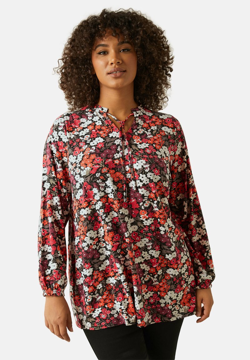 Kukallinen paita pitkillä hihoilla, avainaukko kauluksessa ja nyöri punaisilla, valkoisilla ja violetilla kukilla mustalla taustalla. Pehmeä kangas, rento istuvuus.