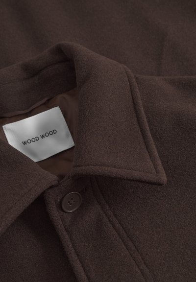Abrigo de lana marrón con un acabado texturizado, que presenta un cuello clásico, cierre de botones y una etiqueta con la inscripción "WOOD WOOD" en el interior.
