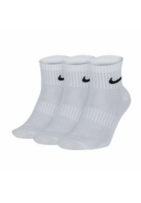 Tre par vita ankelsockor med ribbad krage och en svart Nike-logotyp på sidan, tillverkade av ett mjukt, stretchigt material.