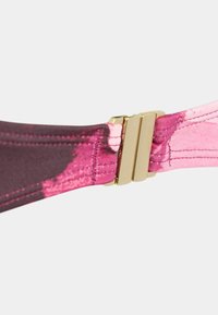 Cinghietta di reggiseno in satin rosa e viola scuro con una texture liscia, dotata di una chiusura dorata e dettagli di cucitura a contrasto.