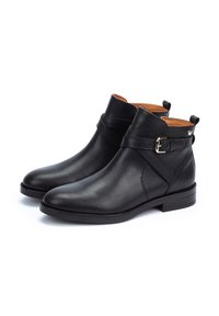 Bottes noires en cuir à la cheville avec une finition lisse, avec un accent en boucle, bout rond et petit talon empilé. Doublure intérieure beige.