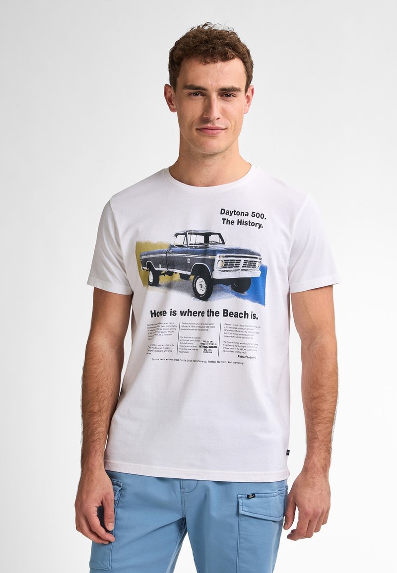 Biała bawełniana koszulka z grafiką niebieskiej vintage'owej ciężarówki oraz napisem o Daytona 500. Okrągły dekolt i krótkie rękawy.