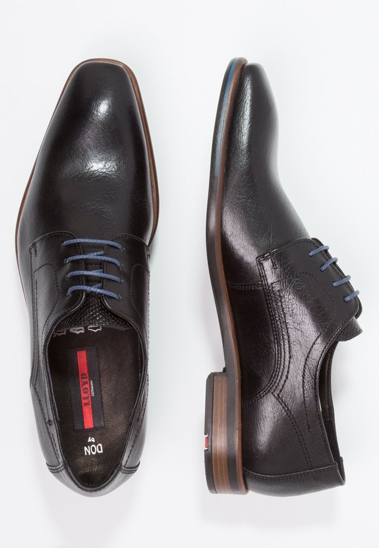Black leather dress shoes with a smooth finish, pointed toe, blue laces, and a brown heel. Features perforated accents near the tongue.
