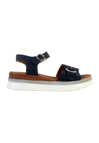 Sandalia azul marino con una correa texturizada, detalle de hebilla, suela de corcho y suela de cuña blanca. Cuenta con una correa adjustable para el tobillo para un mejor ajuste.