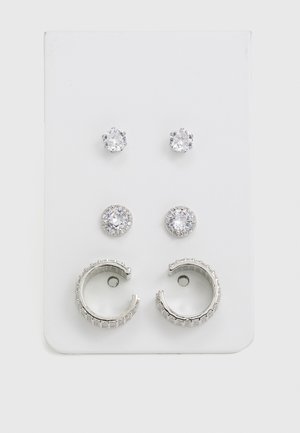 Sada troch párov náušníc: dva páry náušníc s okrúhlymi, čírymi kameňmi a jeden pár strieborných kruhových náušníc s textúrovanými pruhmi.