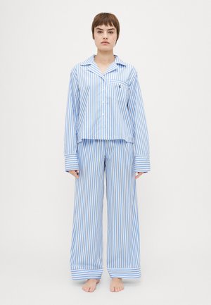 Blue and white striped pajama set with a button-up top and wide-leg pants. Features a chest pocket and cuffed sleeves. Soft cotton fabric.