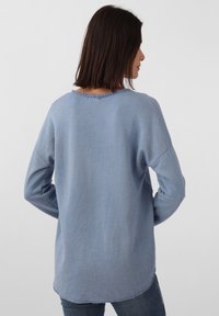 Hellblaues Langarmshirt mit entspannter Passform, mit einem rohen Saum und geripptem Halsausschnitt. Weicher Stoff, lässiges Design.