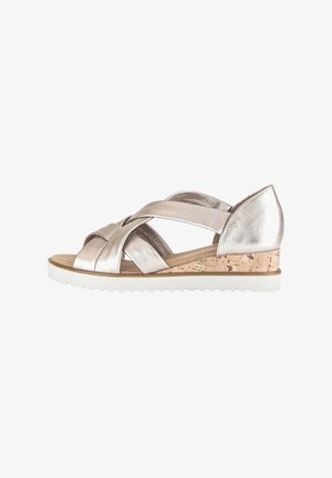 Metallic silver wedge sandals with crossed straps, cork midsole, and white rubber outsole. Features a low heel design for comfort.
