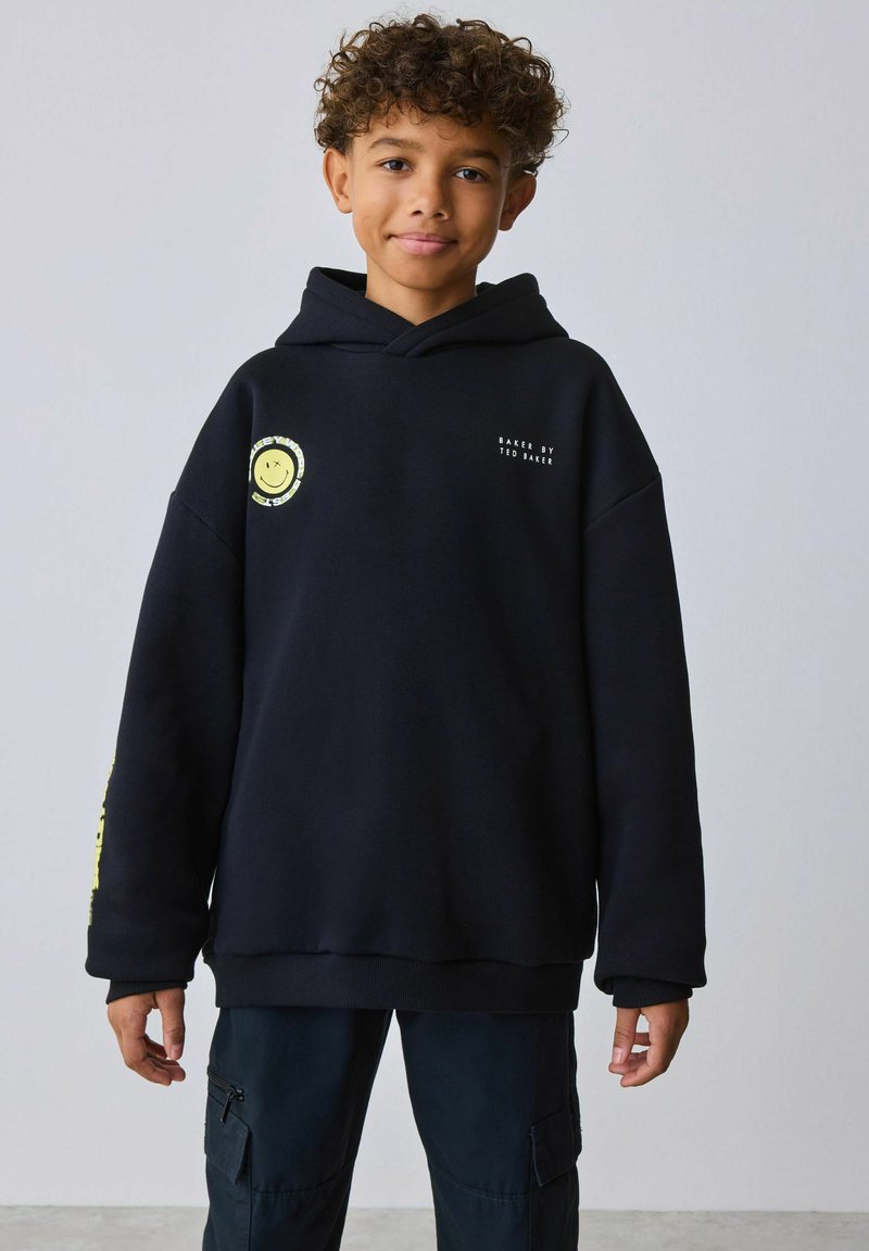 Sweat à capuche noir avec un motif smiley, des accents jaunes et un texte imprimé. Confectionné dans un tissu doux, avec une coupe décontractée et des poignets côtelés.
