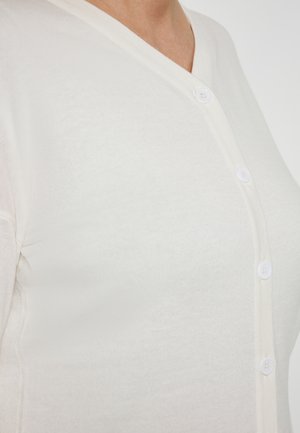 Lichtcreme cardigan met een V-hals, witte knopen langs de voorkant en een zachte, gebreide textuur.