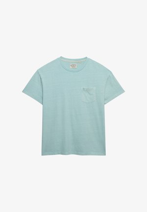 T-shirt bleu clair à manches courtes avec col rond, poche poitrine et étiquette de marque visible à l’intérieur du col sur fond blanc.