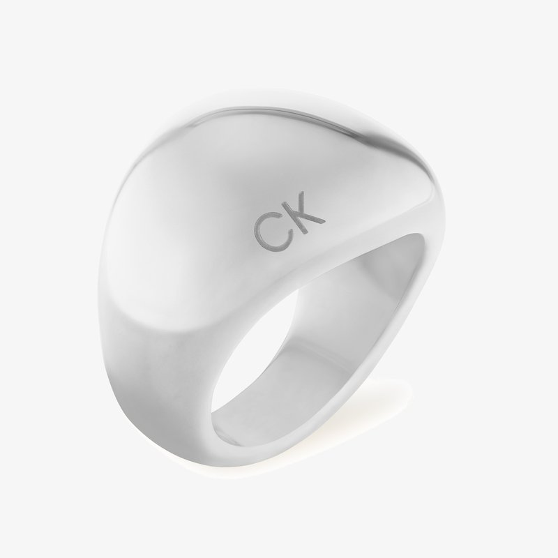Anel prateado com um design suave e curvado. Apresenta um acabamento polido e o logotipo gravado "CK", exibindo uma estética minimalista.