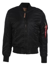 Veste bomber noire avec fermeture éclair avant, poignets et ourlet côtelés, poche zippée sur la manche gauche avec étiquette rouge "Remove Before Flight".