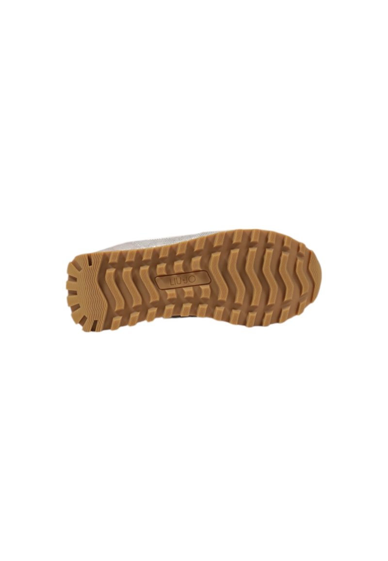 Suela de una zapatilla que presenta una suela de goma texturizada con un patrón en zigzag y una marca en el centro, en tonos de marrón y beige.