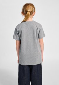 Grå t-shirt med korta ärmar och rund halsringning, tillverkad av bomullsblandat tyg. Bild från baksidan visar en slät textur och avslappnad passform.