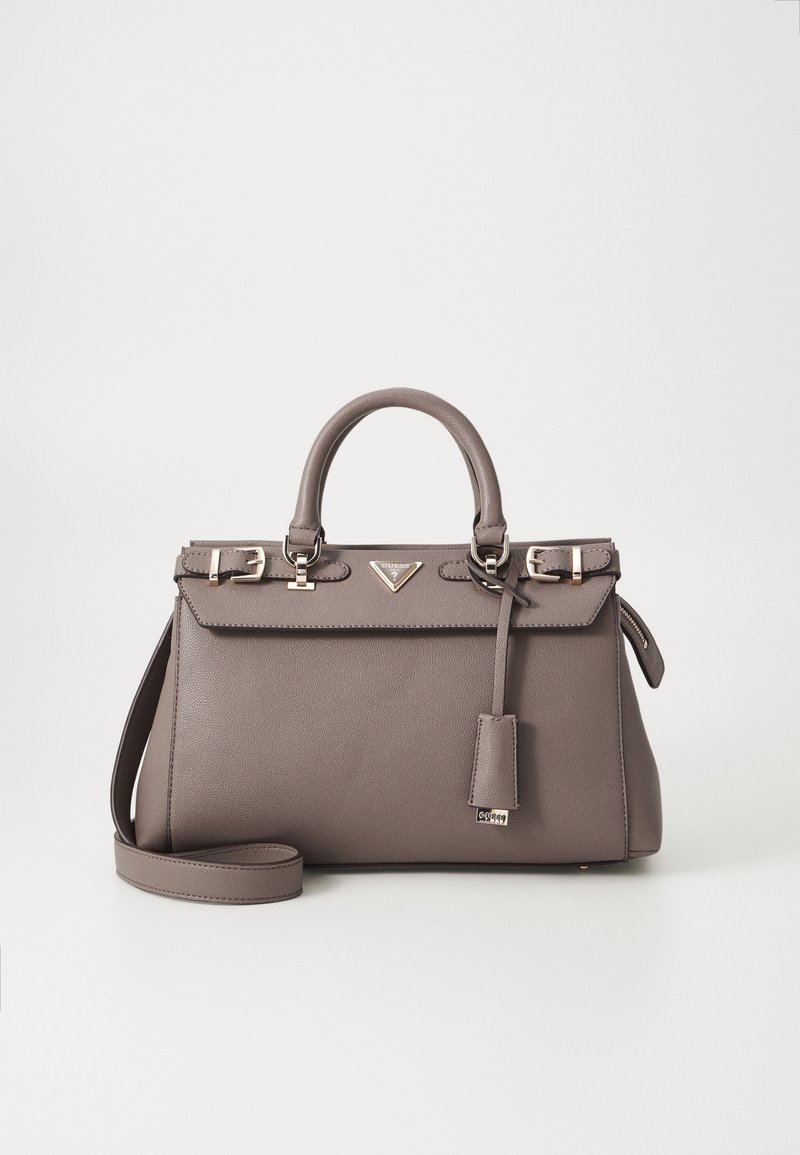 Sac à main en cuir taupe avec doubles poignées, bandoulière amovible, boucles argentées et petite plaque avec logo à l’avant.