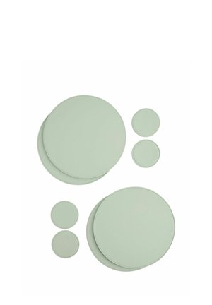 Sei sottobicchieri rotondi in pelle verde pastello di due dimensioni grandi e quattro piccole disposti su uno sfondo bianco.