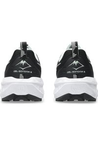 Black and white athletic shoes with a cushioned sole, mesh upper, and a pull tab. Features logo and textured outsole for grip.