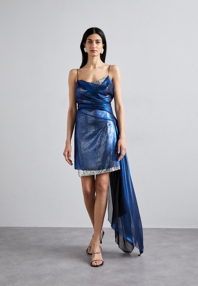 Blaues Satinkleid mit asymmetrischem Saum, verziert mit silbernen Pailletten und schwarzem, transparentem Überzug. Spaghettiträger und schlanker Schnitt.