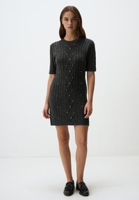 Robe tricotée grise avec un motif texturé et des manches courtes. Présente des accents décoratifs et une coupe ajustée.