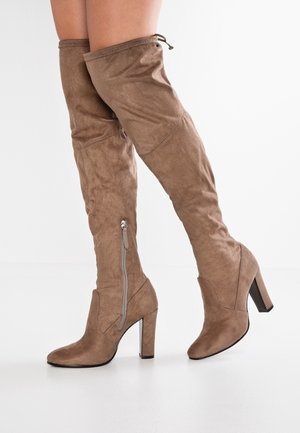 Braune Wildleder-Stiefel bis zum Oberschenkel mit spitz zulaufender Zehenpartie, hohem Blockabsatz und seitlichem Reißverschluss. Weiche Textur mit einer Schnur am oberen Teil.
