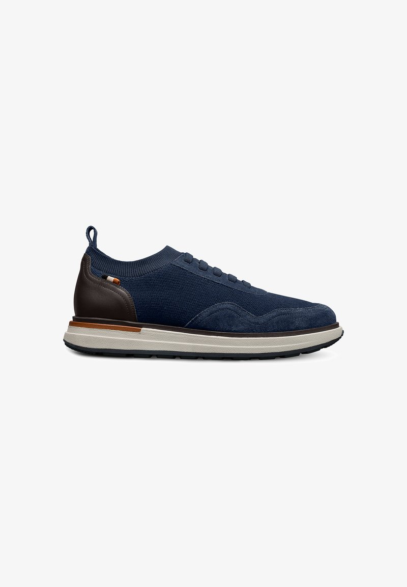Scarpe in tessuto a maglia blu navy con accenti in suede, suola in gomma grigia, tacco in pelle marrone e un dettaglio di allacciatura minimale, dotate di una linguetta sul retro.