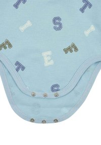 Světle modrý overal s texturovaným povrchem, zdobený potiskem písmen v různých barvách. Obsahuje kovové cvoky na dně.